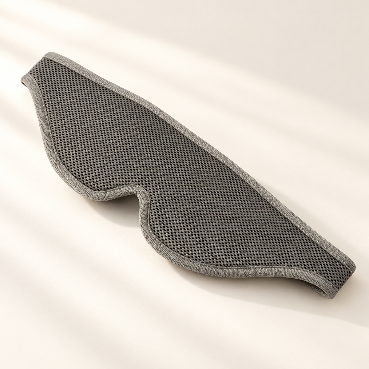 Adjustable 3D Blackout Sleep Mask on a warm ivory studio background
