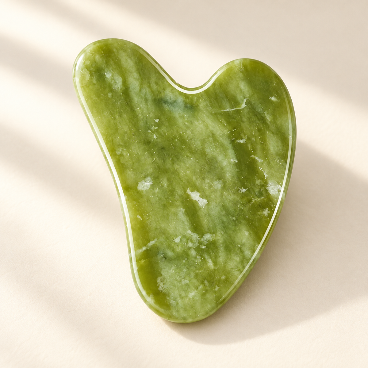 Natural Stone Gua Sha Massage Tool on a warm ivory studio background