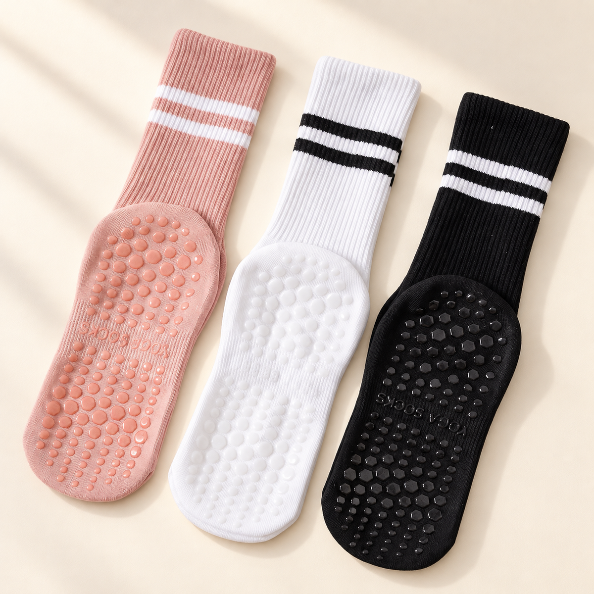 Pilates Grip Socks, 3-Pair Pack in Black, White & Pink on a warm ivory studio background