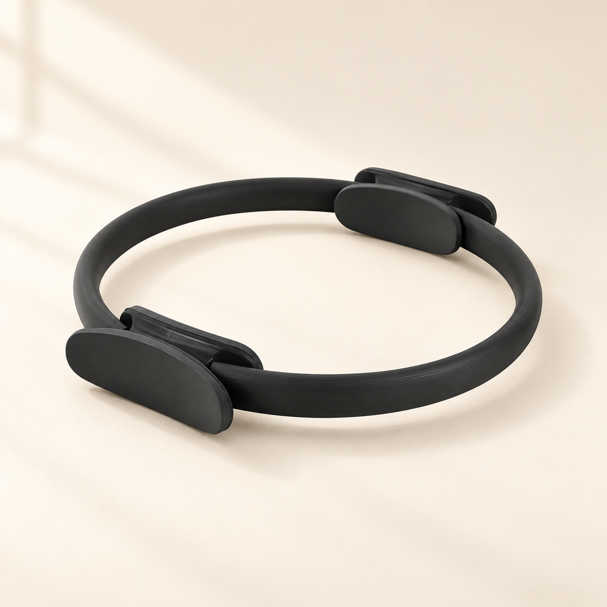 Pilates Resistance Ring with Padded Handles, 35 cm on a warm ivory studio background